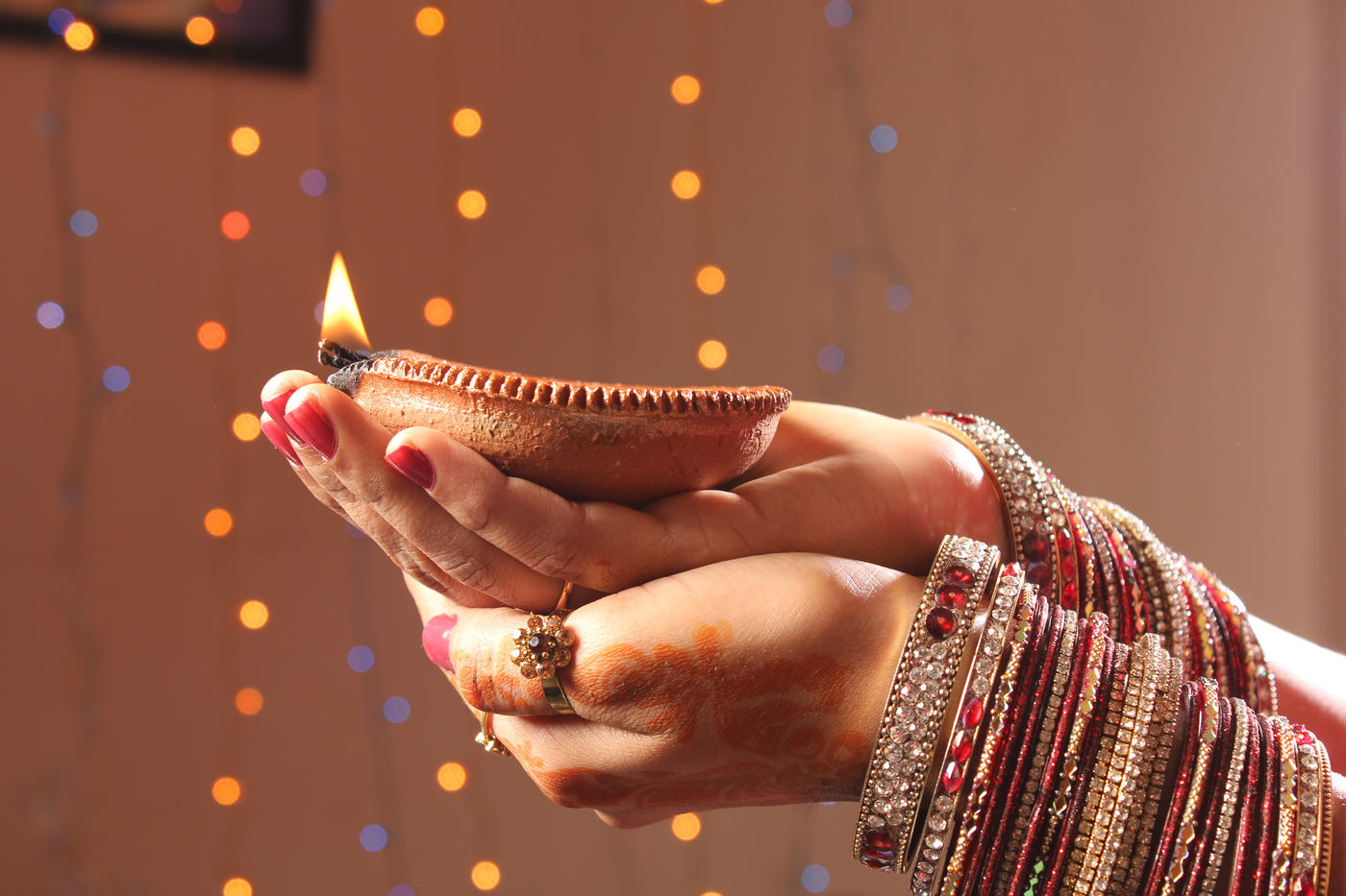 Hands holding a candle for Diwali